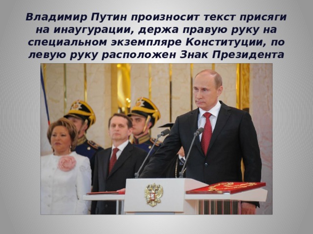 Владимир Путин произносит текст присяги на инаугурации, держа правую руку на специальном экземпляре Конституции, по левую руку расположен Знак Президента